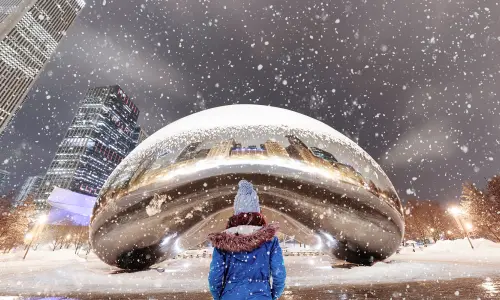 Girl looking at The Bean in the Winter
