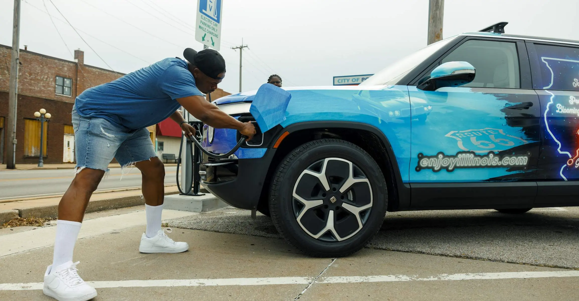 A person charges a Rivian electric vehicle