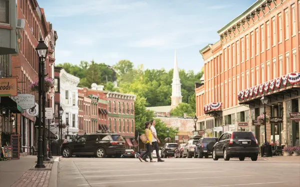 A couple walking across the main street in Galena with buildings either side