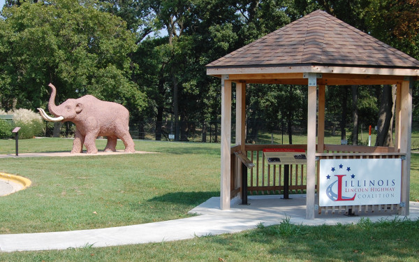 A pavilion with an elephant statue in the background 