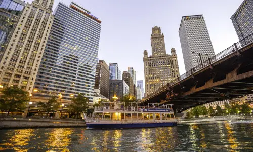 A boat on the water with the big city buildings behind it