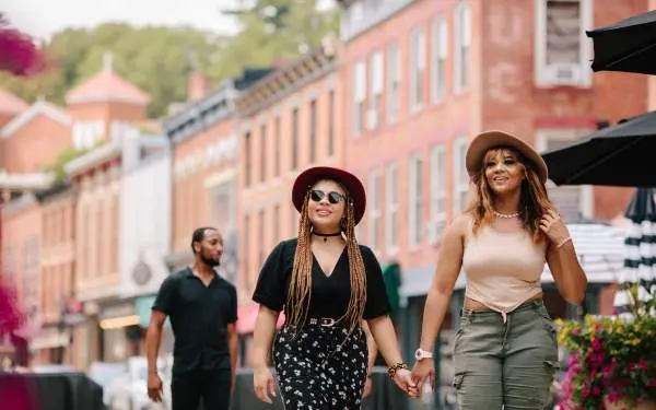 Two women walking down the main street of Galena, with brick buildings in the background