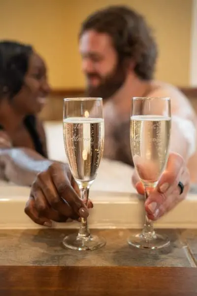 Couple having champagne in the bath tub.