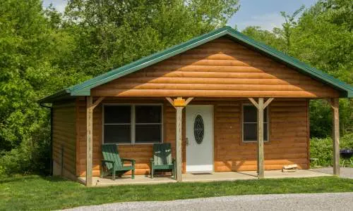 The exterior of a wooden cabin surrounded by greenery