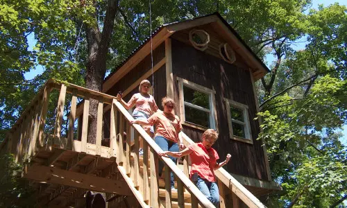 A cabin house with woman walking down the stairs