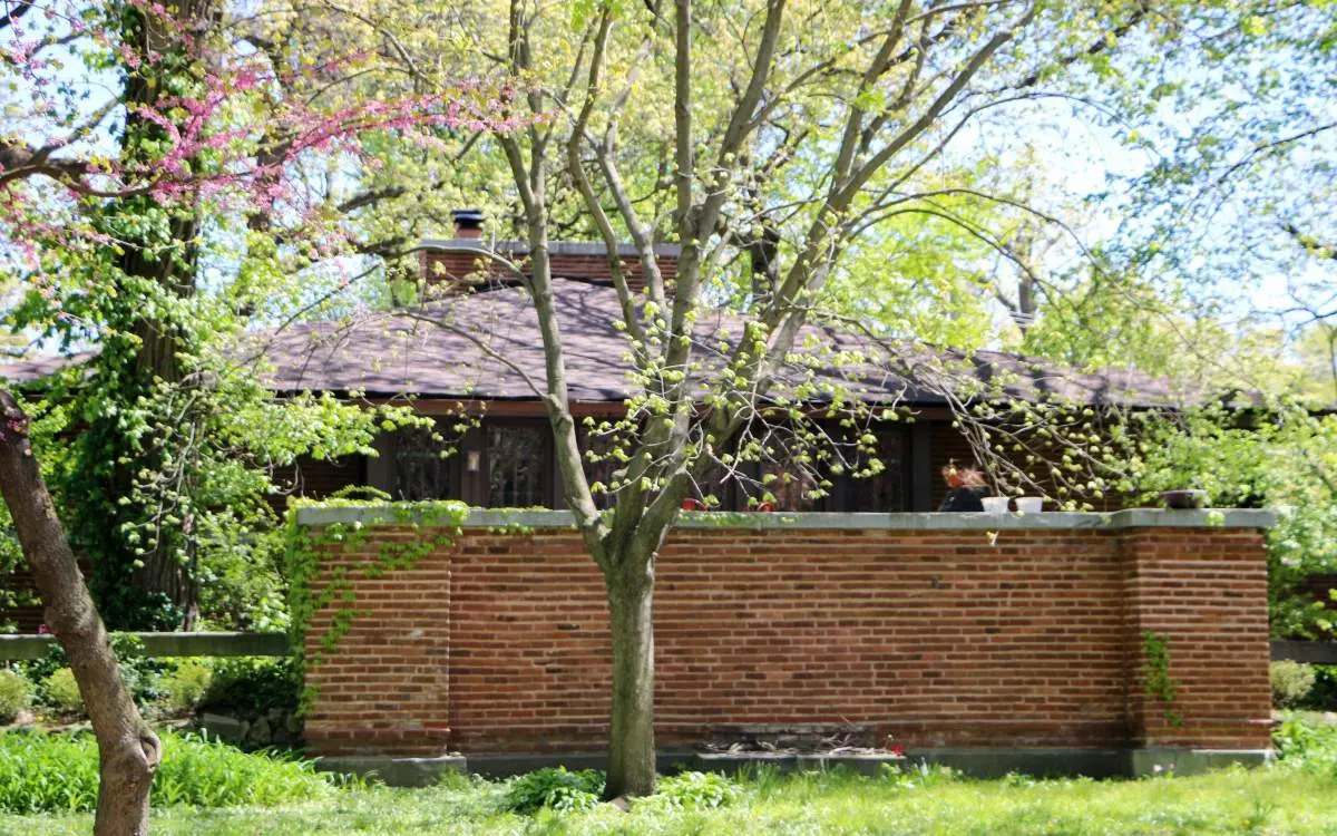 The exterior of a house with a brick fence infront