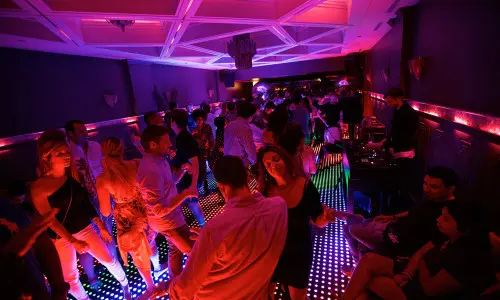 Patrons dancing on a lit up dance floor