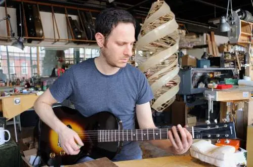 Student tests a guitar.