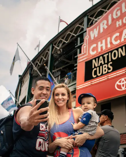 Family posing for a photo outside of a stadium