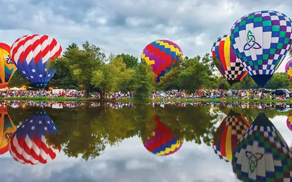 Hot air balloons surround a lake (Photo Don Burkett)