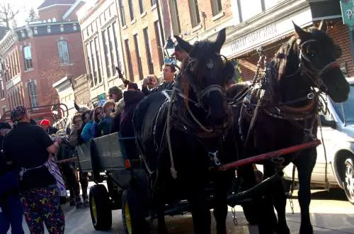 A horse cart carrying people down a street