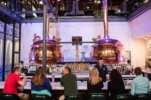 Patrons sit at a bar