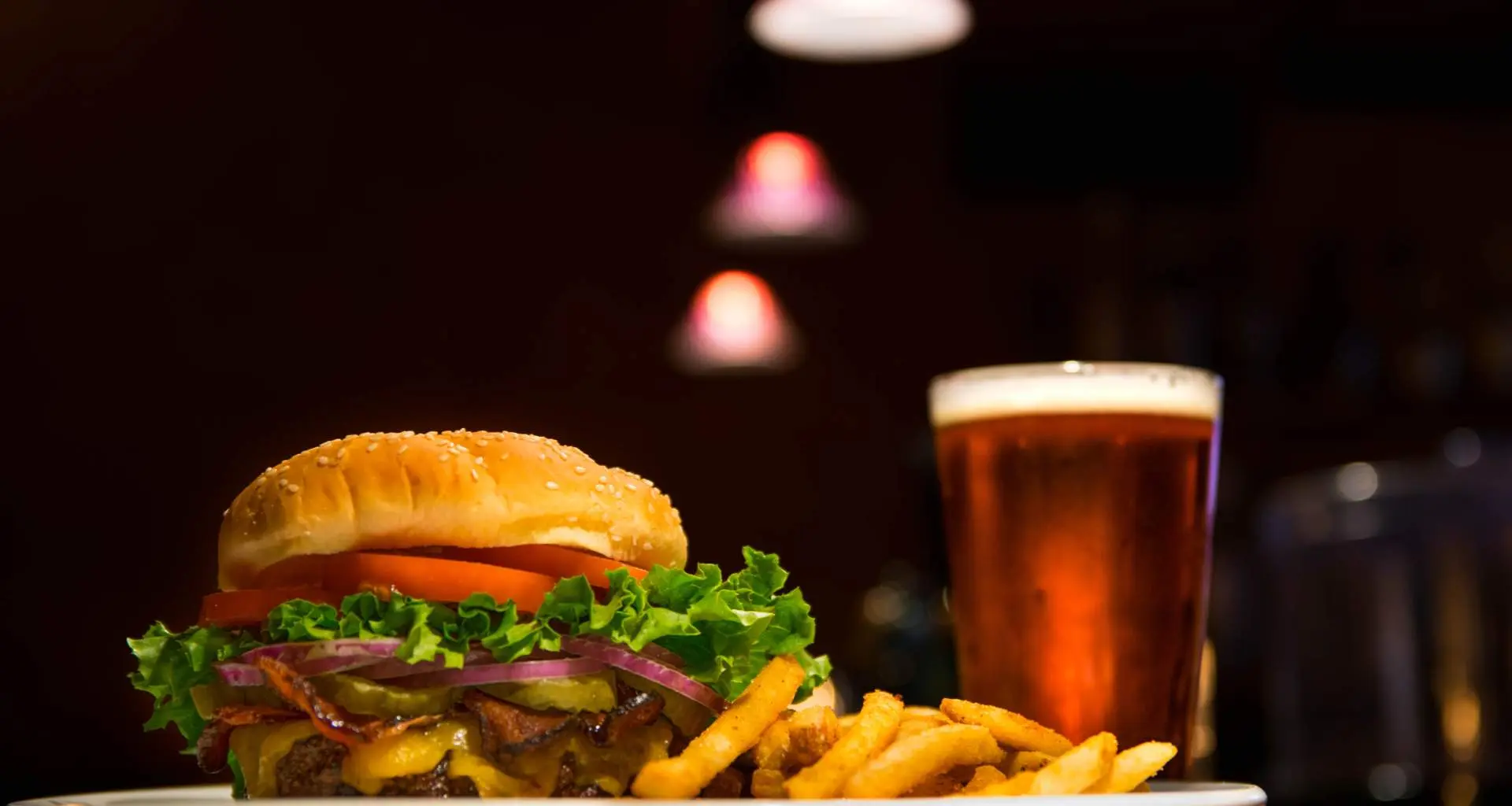 A burger with fries and a beer