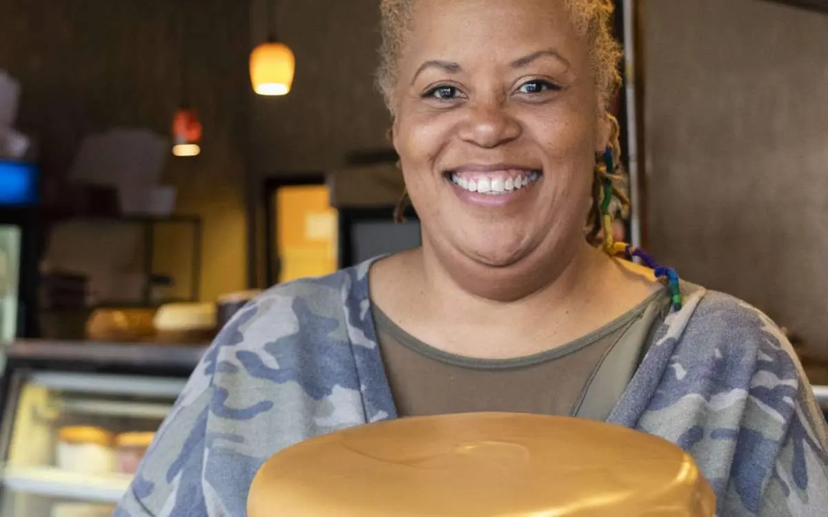 A woman smiling holding a cake