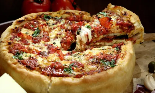 A slice of deep dish pizza being served