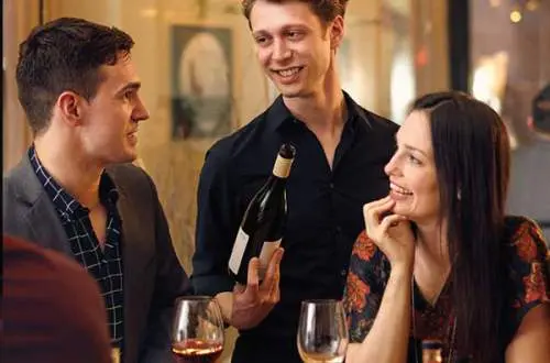 Waiter offering couple wine