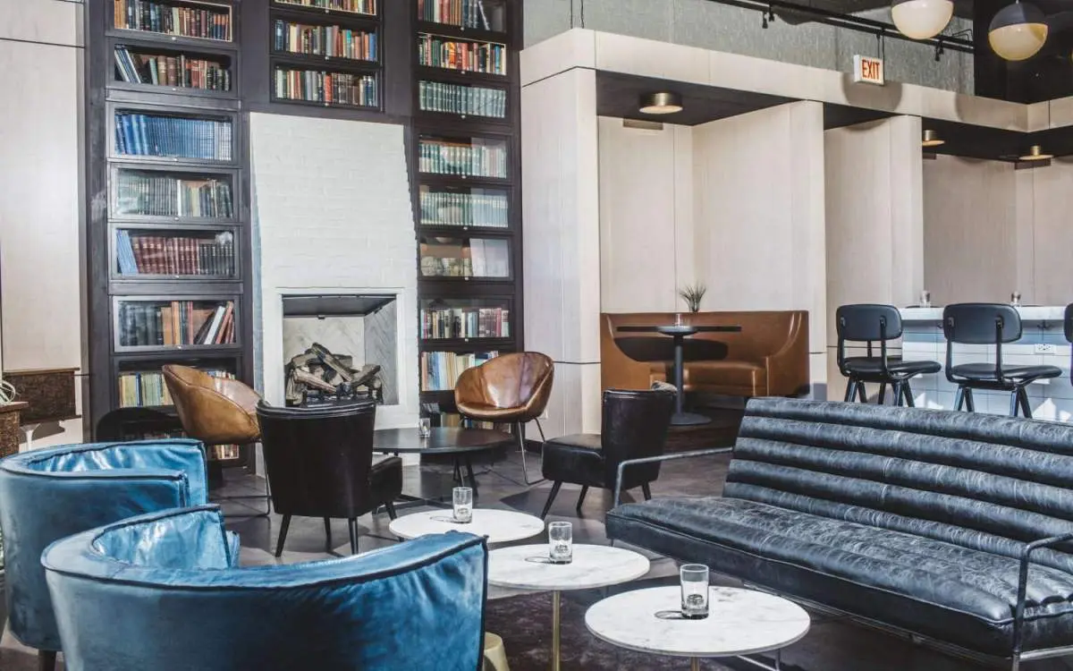 Restaurant with multiple seating set up and a bookshelf fireplace.