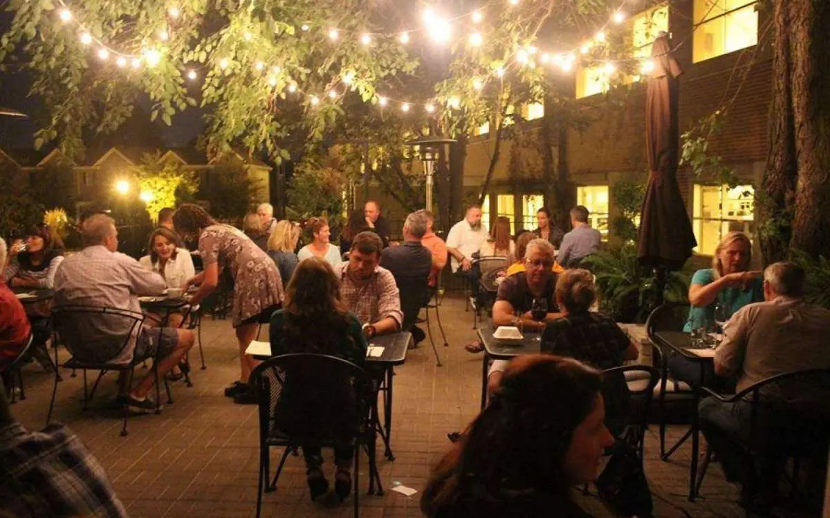 Customers sat at tables under lights to eat