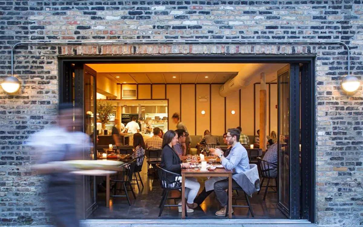 A view of customers eating through the open restaurant doors