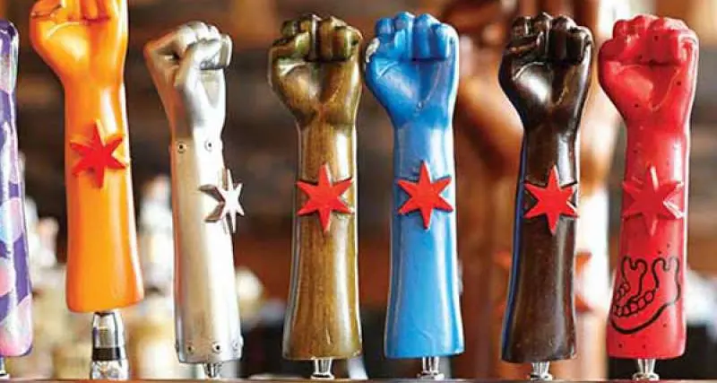 A line up of seven Revolution Brewing beer tap handles in the shape of fists