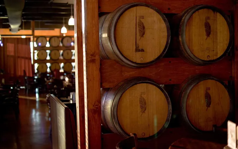 A row of wine barrels in a dark room