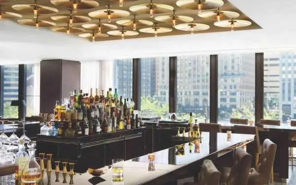 Interior of a bar with lots of windows to look out into the city.