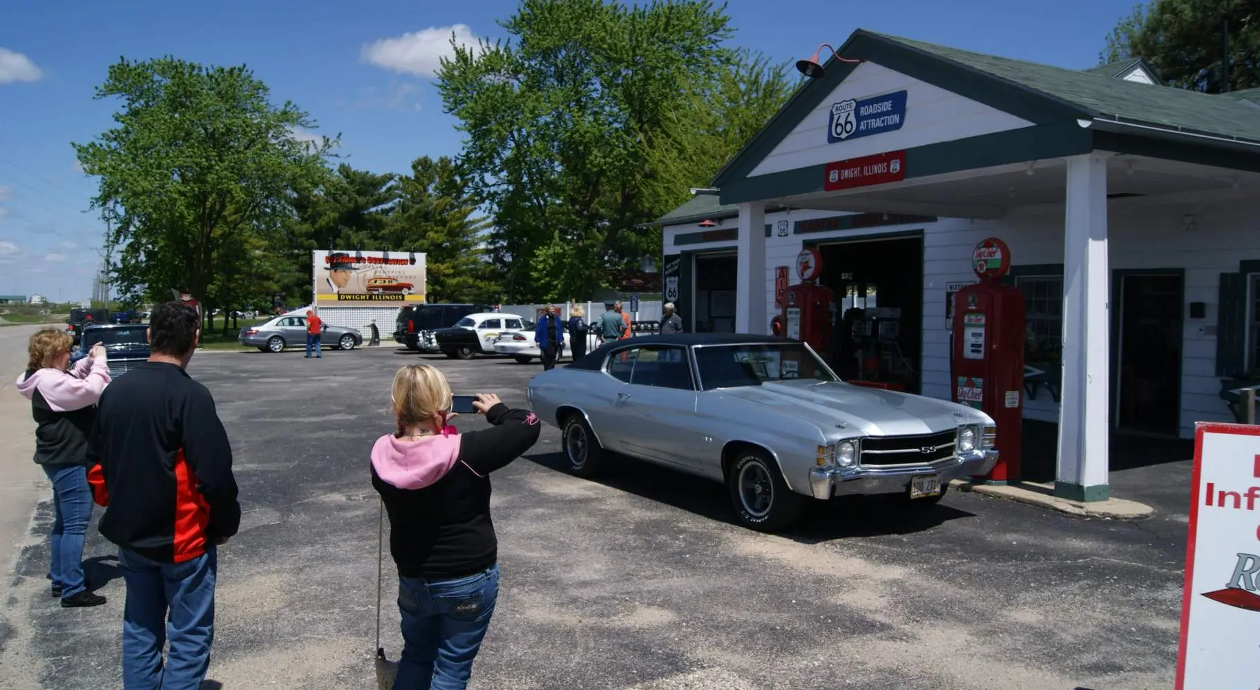 People taking photos of a historic gas station