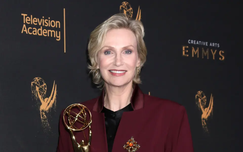 Jane Lynch holding her emmy award