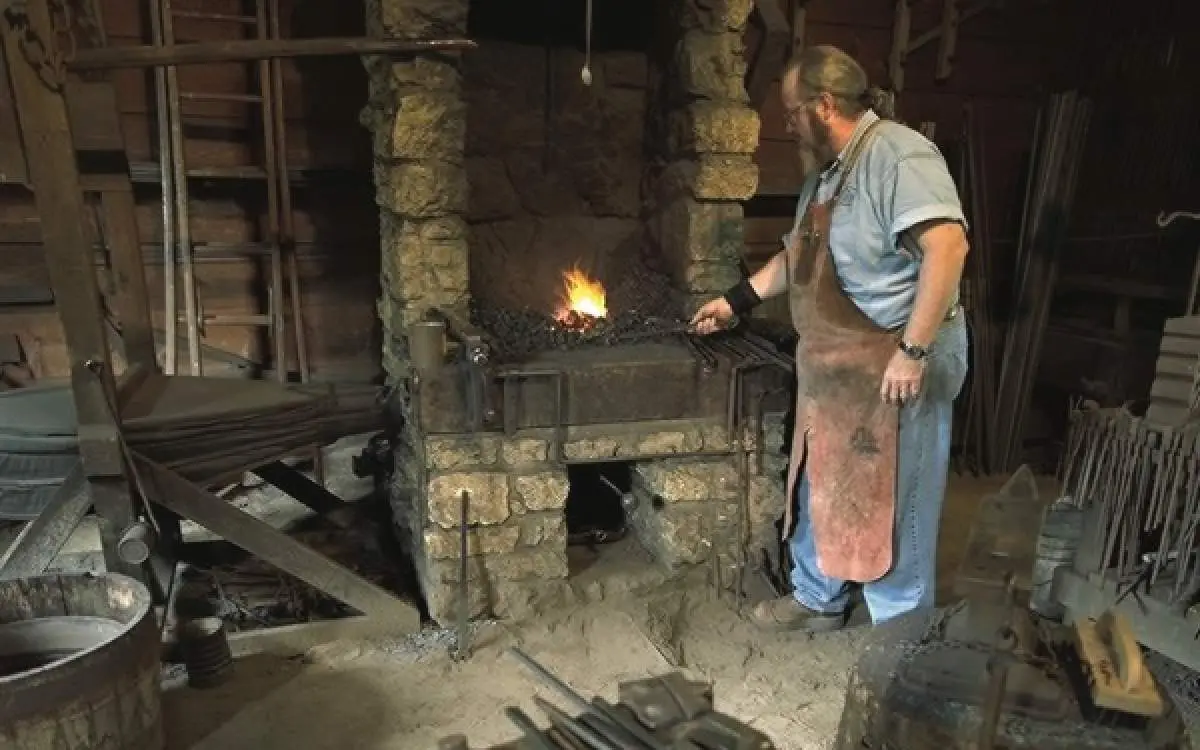 A man poking a fire with a rod