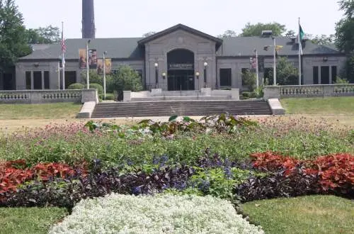The exterior of a building with a flower garden in front