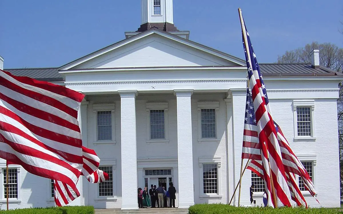 A large white house with American flags out front