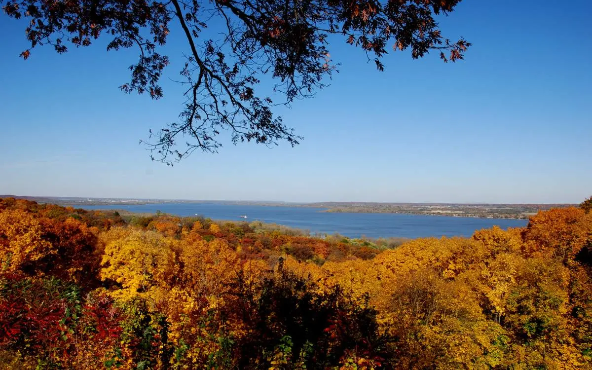 A viewpoint over a forest with fall colors looking towards Peoria Lake