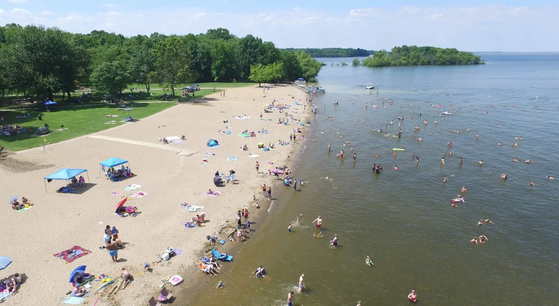 An aerial view of a beach with people enjoying the sun, sand and water