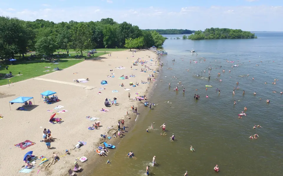 An aerial view of a beach with people enjoying the sun, sand and water