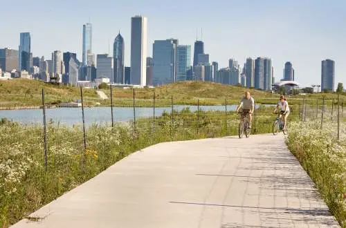 Bikers biking down road beside lake