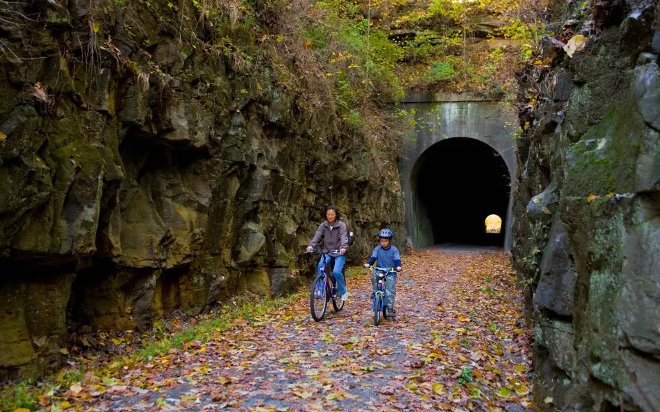 Two people biking through a tunnel