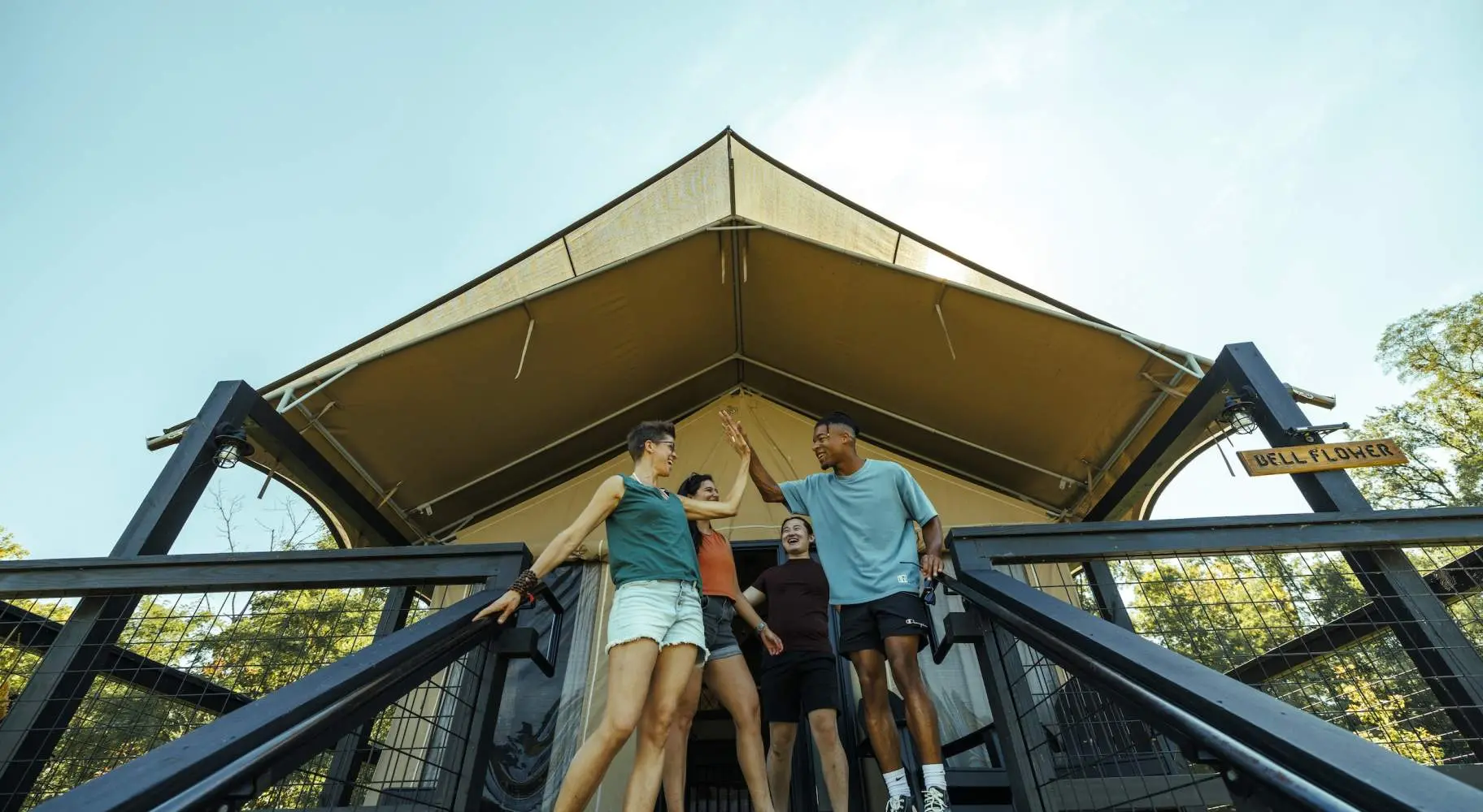 People outside of a glamping tent at Camp Aramoni