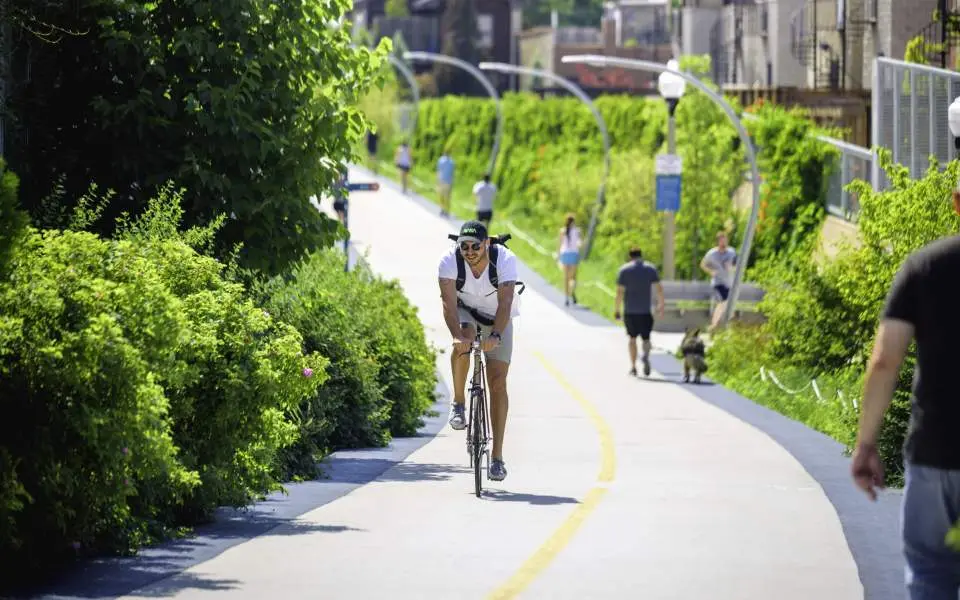A cyclist riding a bike on an urban mixed use trail