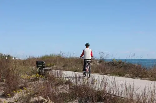 Person biking along beach line path