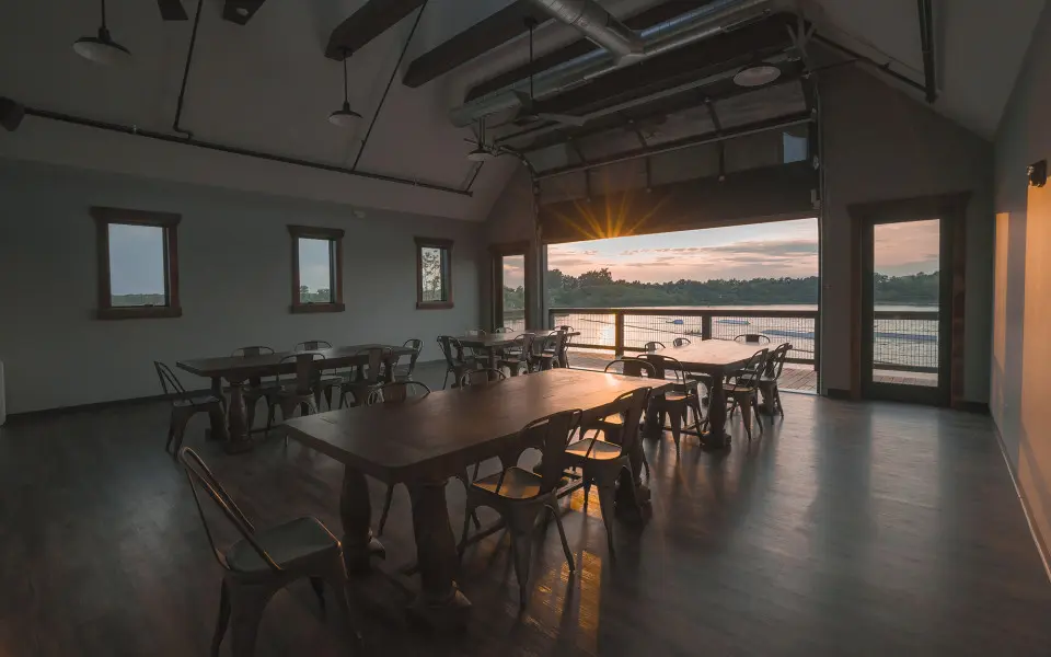 Photo of a room with tables and chairs overlooking the quarry cable park