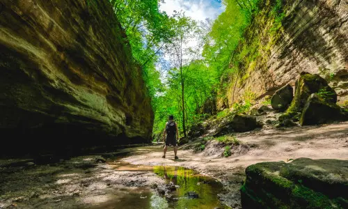 A man stands between two rockfaces