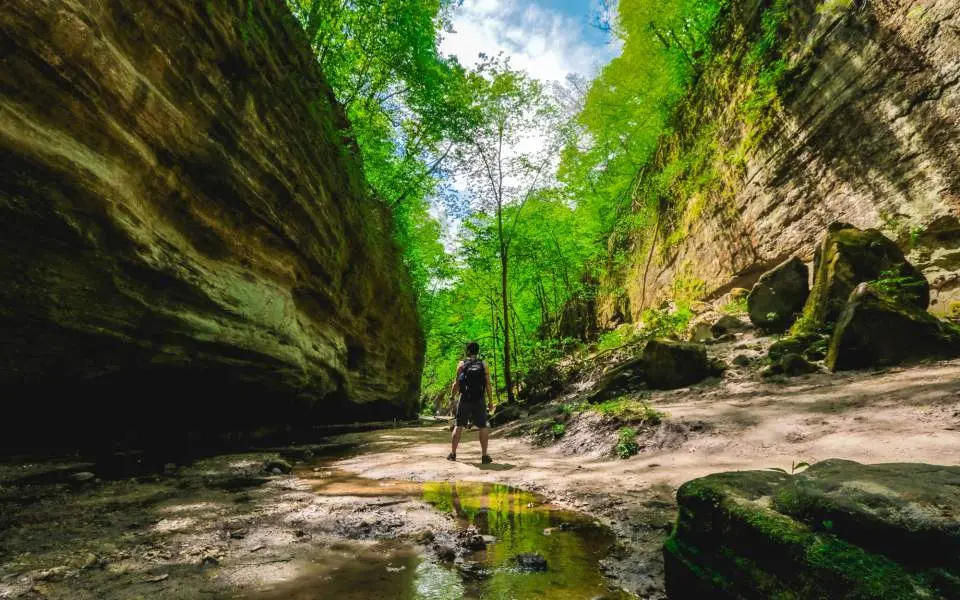 A man stands between two rockfaces