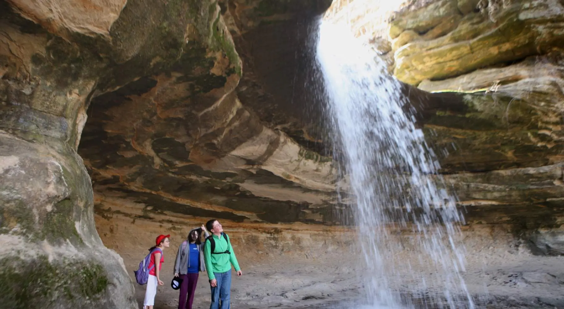 People looking up at a waterfall