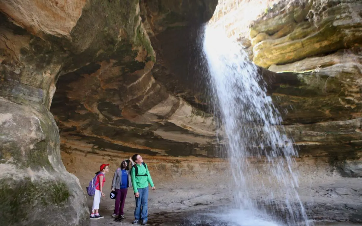 People looking up at a waterfall