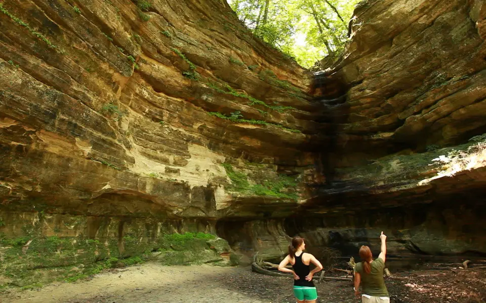 Two people looking up at the large rock surrounding