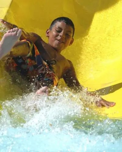 Child coming down yellow Great America Hurricane Harbor water slide