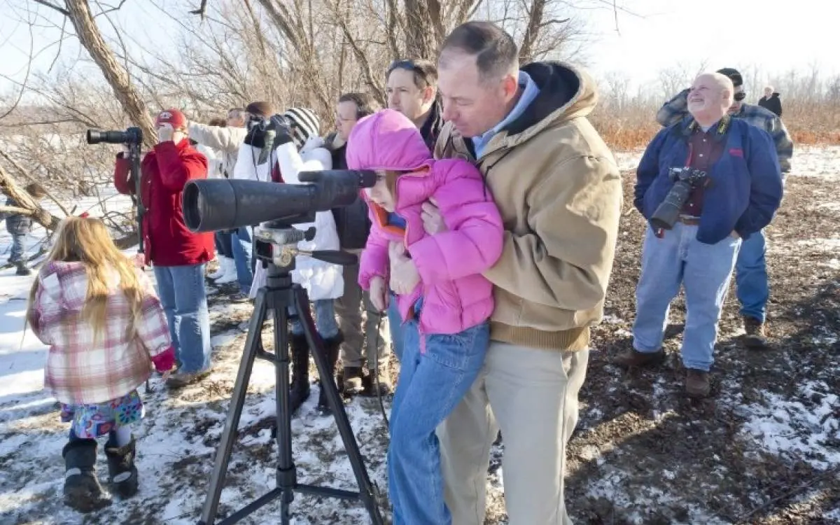 People looking through large camera lense