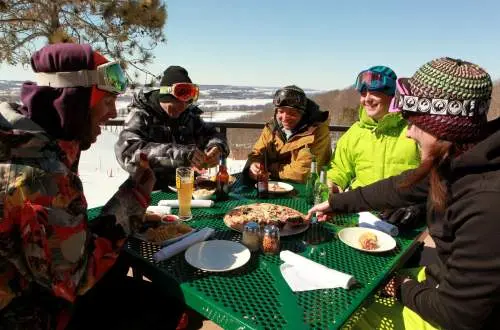 Group of Pizza in ski gear eating pizza