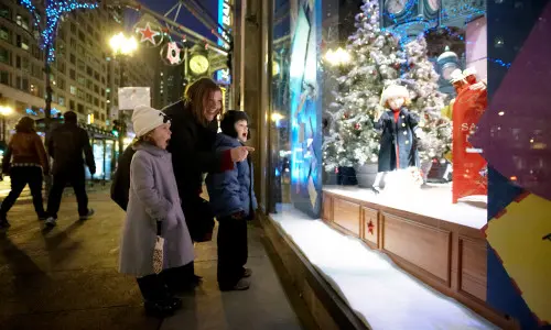 Woman and kids looking outside in to window display