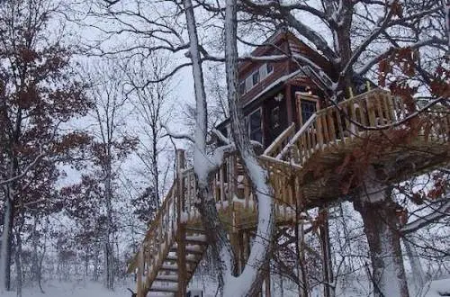 Log cabin in the middle of the forest covered in snow.